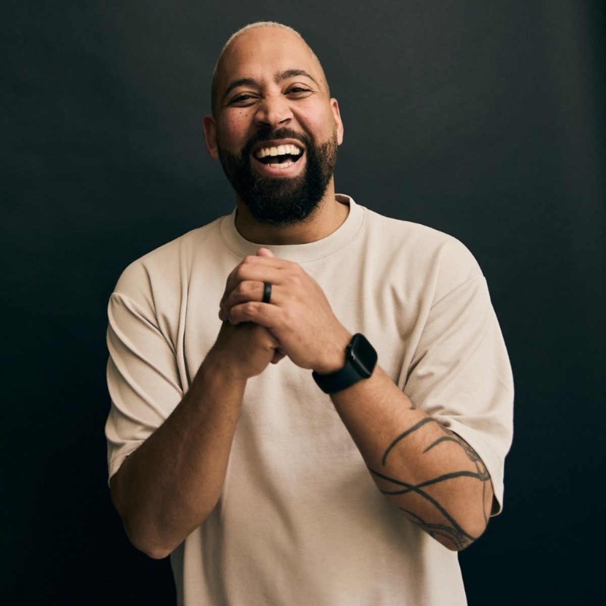 Ashley Aubrey laughing, studio portrait on a dark background